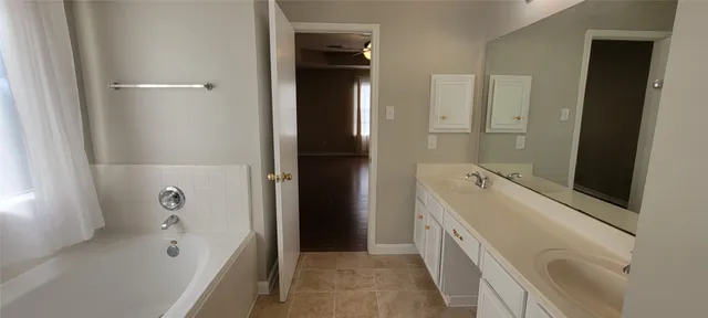 a bathroom with a tub sink and mirror
