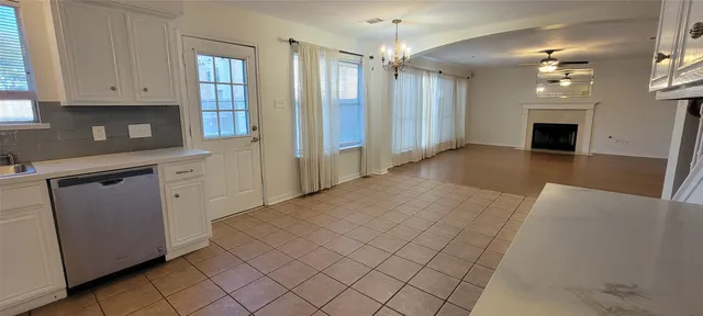 a view of a livingroom with a chandelier fan and windows