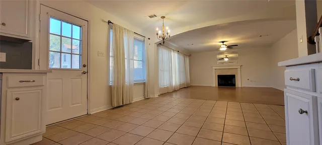 a view of an empty room with window and cabinet