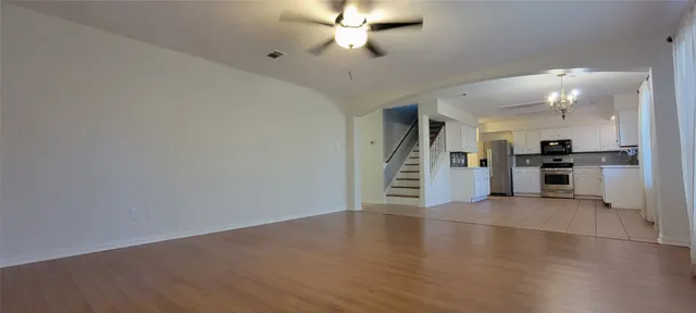 a view of a kitchen with wooden floor and electronic appliances