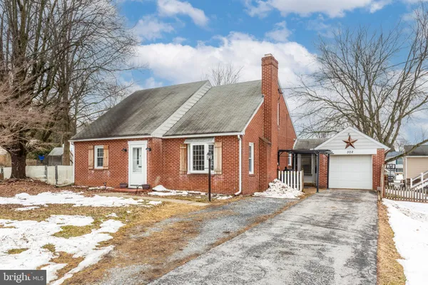 a front view of house with a yard covered with snow