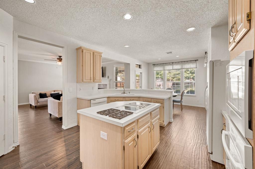 417 Shade Tree Circle Hurst, TX 76054 - Photo 11 of 39 a open kitchen with stainless steel appliances granite countertop a stove top oven a sink dishwasher white cabinets and couches with wooden floor