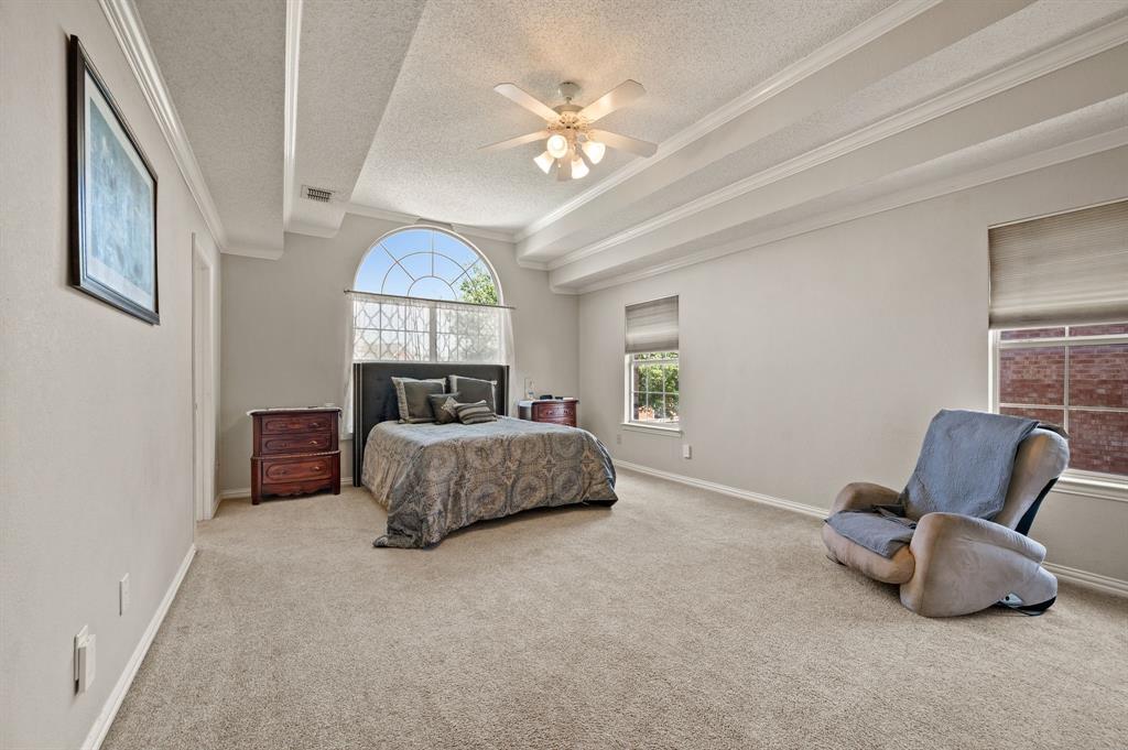 417 Shade Tree Circle Hurst, TX 76054 - Photo 21 of 39 a bedroom with a bed and a chandelier