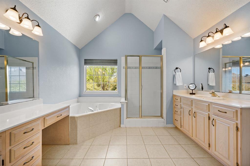 417 Shade Tree Circle Hurst, TX 76054 - Photo 24 of 39 a spacious bathroom with a granite countertop sink a mirror a bathtub and next to a window