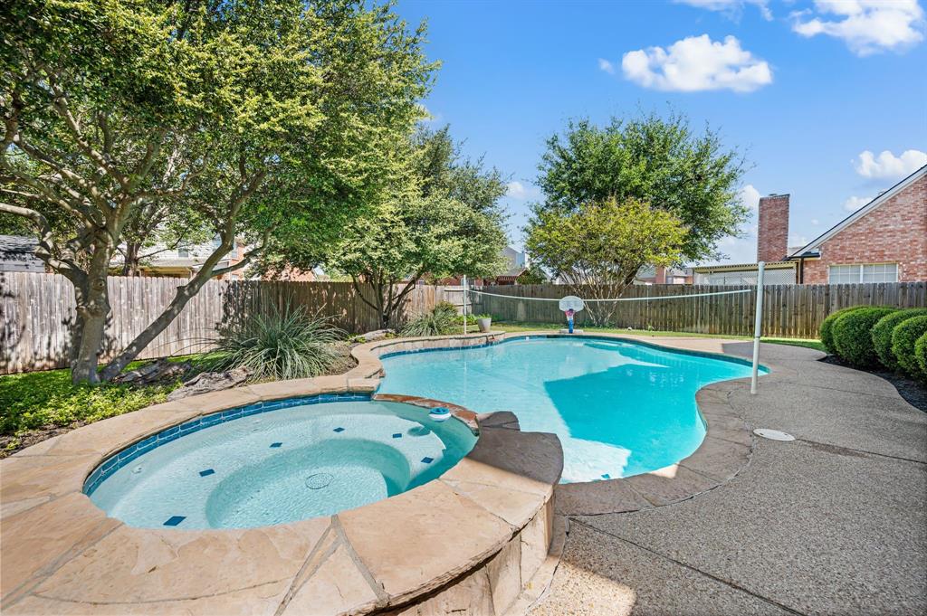 417 Shade Tree Circle Hurst, TX 76054 - Photo 3 of 39 a view of a swimming pool with a lounge chair and trees in the background