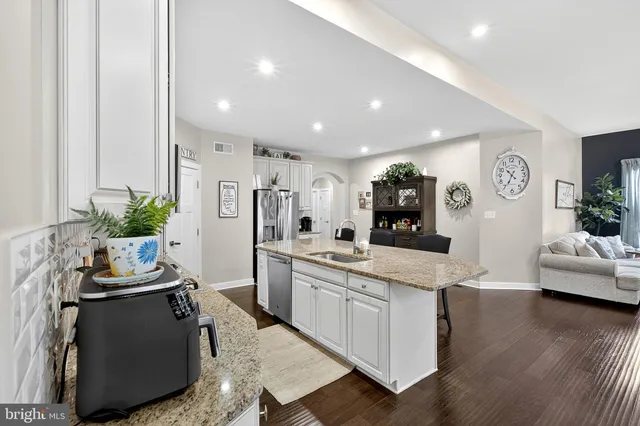a living room with furniture and a dining table with kitchen view