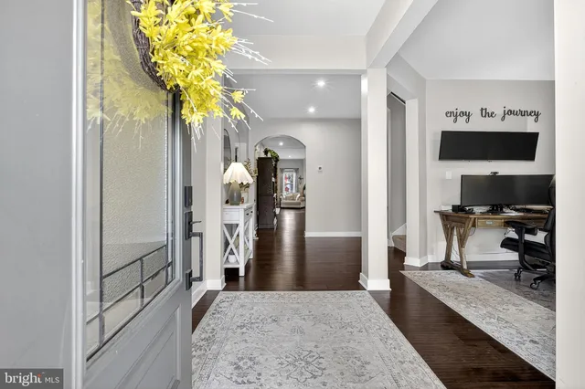 a view of a hallway with wooden floor fireplace and living room