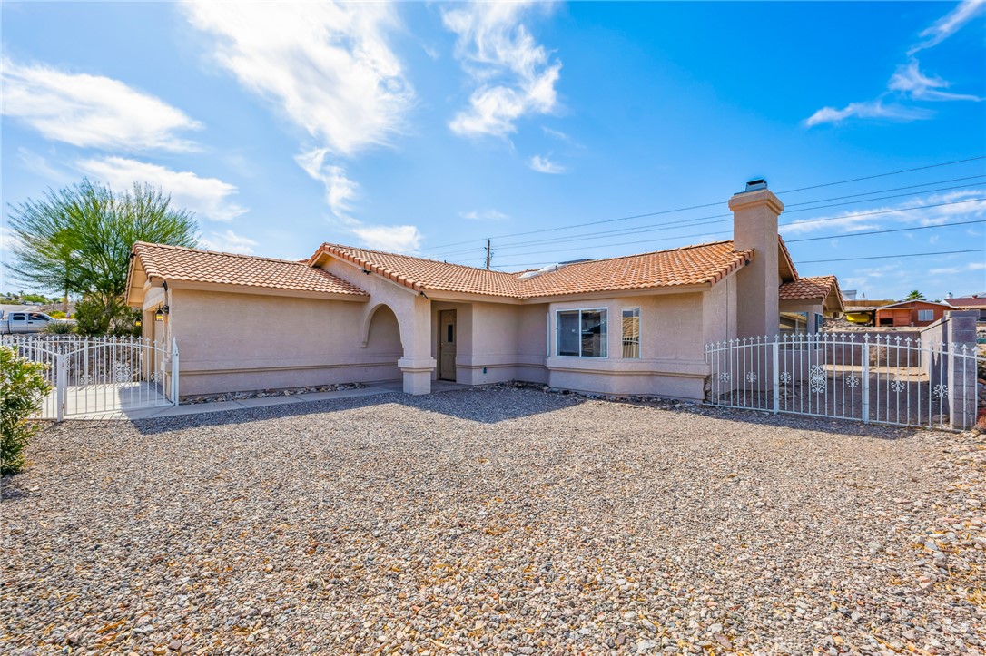 2524 South Ridge Avenue Bullhead City, AZ 86429 - Photo 9 of 64 Mediterranean / spanish-style home featuring a tile roof, stucco siding, a gate, and a chimney