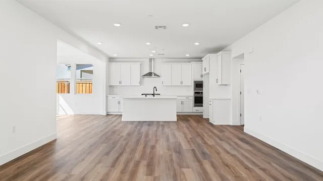 a view of kitchen with wooden floor and electronic appliances