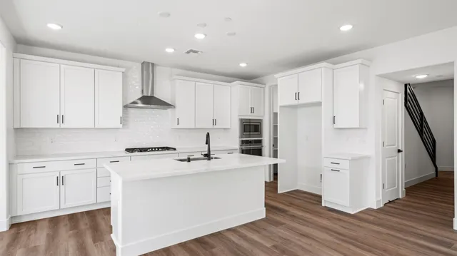 a kitchen with stainless steel appliances a refrigerator sink and cabinets