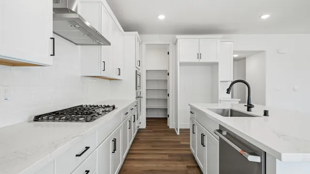 a kitchen with stainless steel appliances a sink stove and cabinets