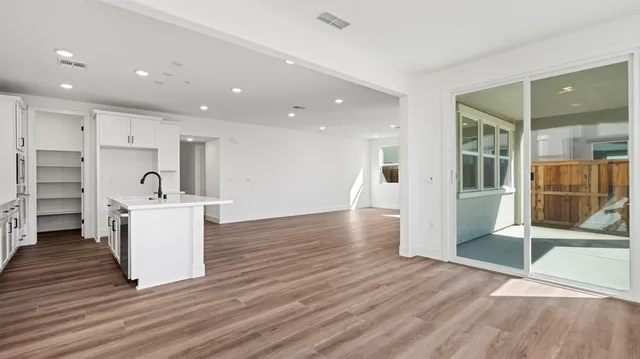 a view of a kitchen with wooden floor and a sink