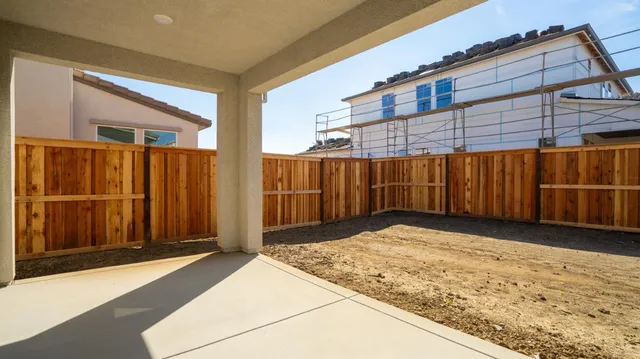 a view of backyard with wooden fence