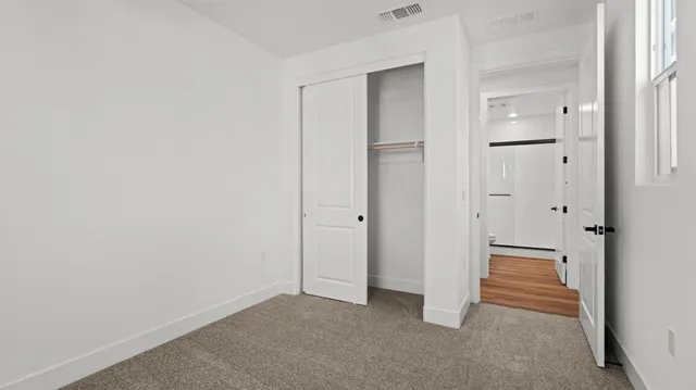 a view of a hallway with closet and wooden floor