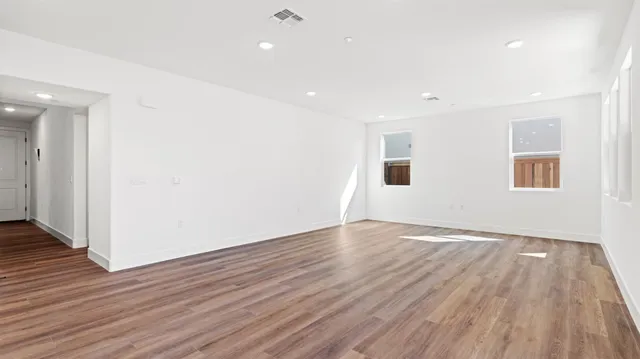 a view of an empty room with wooden floor