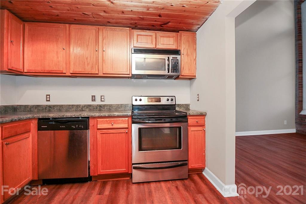 201 South Hoskins Road, Unit 237 Charlotte, NC 28208 - Photo 13 of 46 a kitchen with stainless steel appliances granite countertop a stove a sink and a microwave