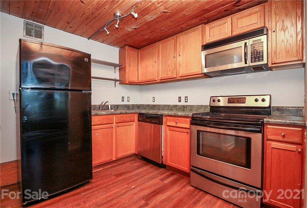 201 South Hoskins Road, Unit 237 Charlotte, NC 28208 - Photo 10 of 46 a kitchen with stainless steel appliances granite countertop a stove a refrigerator and a microwave