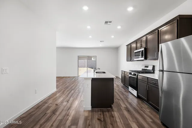 a kitchen with stainless steel appliances granite countertop a sink stove and refrigerator