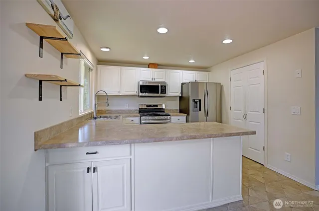 a kitchen with stainless steel appliances granite countertop a refrigerator stove and microwave