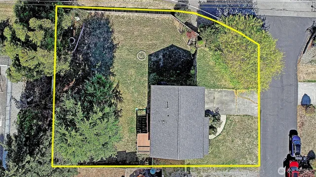 an aerial view of a house with a swimming pool a yard and a mountain view in back