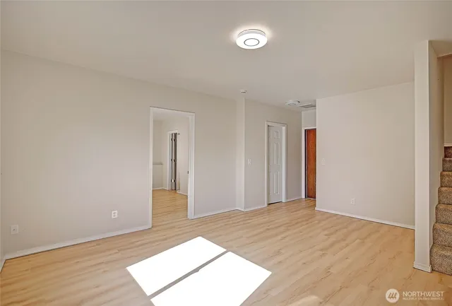 a view of a big room with wooden floor and entryway