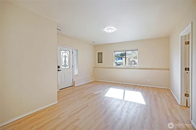 an empty room with wooden floor and windows