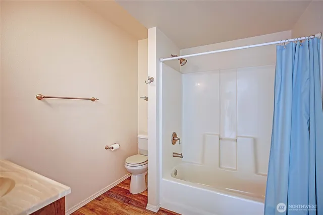 a bathroom with a granite countertop bathtub shower and toilet