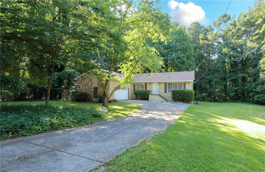 a front view of a house with a yard and trees