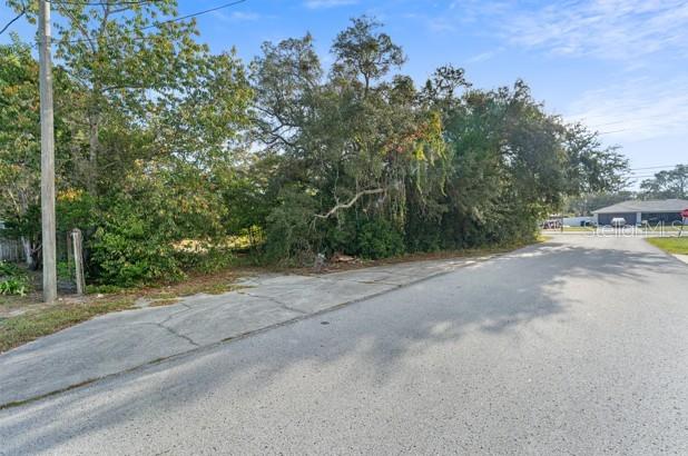 3263 Deltona Boulevard Spring Hill, FL 34606 - Photo 17 of 18 a view of a road with trees in the background
