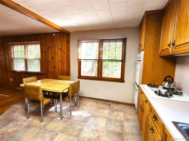 a kitchen with stainless steel appliances granite countertop a stove a sink dishwasher and a refrigerator with wooden cabinets