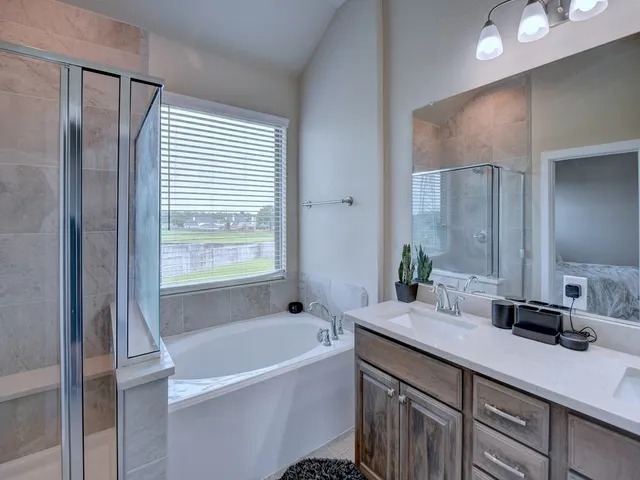 a bathroom with a granite countertop sink mirror and a bathtub