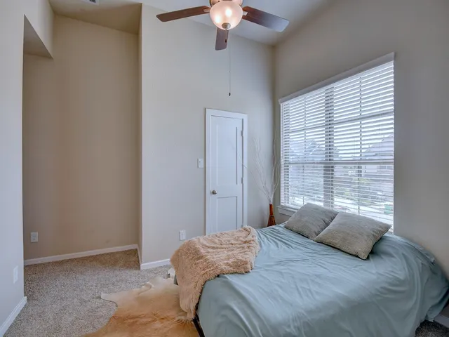 a bedroom with a large bed and a chandelier