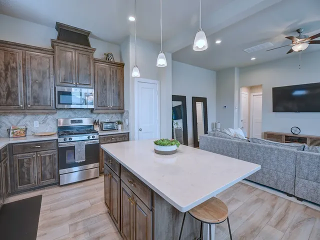 a kitchen with kitchen island a sink stove and refrigerator