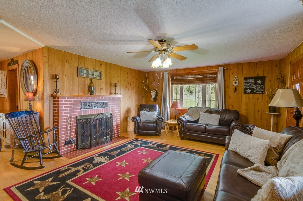 153 Brownlee Road Castle Rock, WA 98611 - Photo 8 of 25 a living room with furniture a dining table and a fireplace
