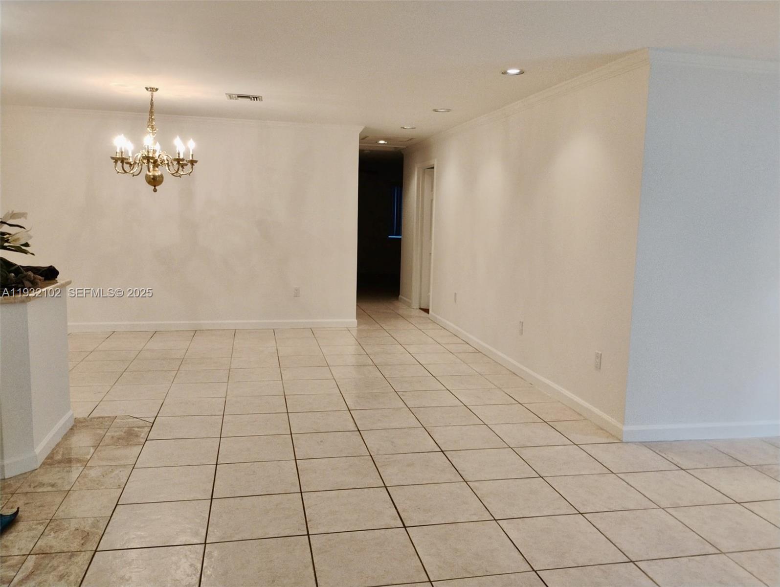 16021 Southwest 173rd Avenue Miami, FL 33187 - Photo 26 of 30 an empty room with white walls and chandelier