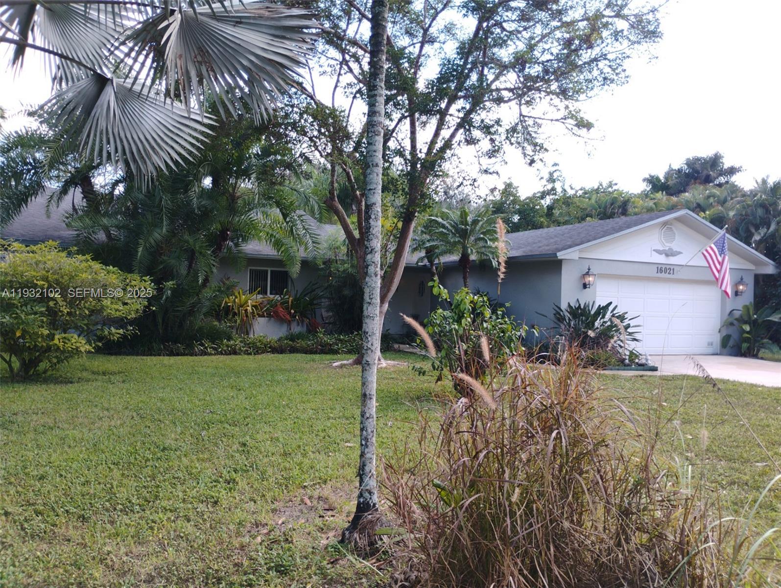 16021 Southwest 173rd Avenue Miami, FL 33187 - Photo 3 of 30 a view of a house with a yard and plants