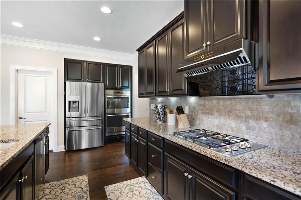 4449 Walnut Ridge Circle McDonald, PA 15057 - Photo 13 of 40 a kitchen with stainless steel appliances granite countertop a stove a refrigerator and wooden cabinets