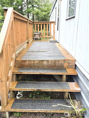 a view of backyard with wooden deck and outdoor seating