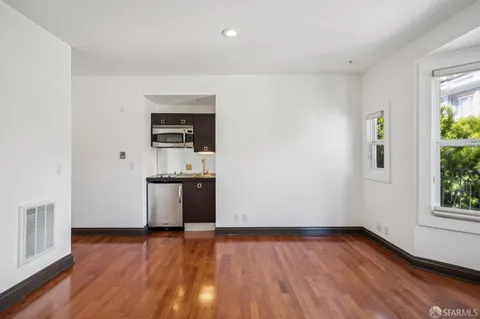 a view of a kitchen with wooden floor and electronic appliances