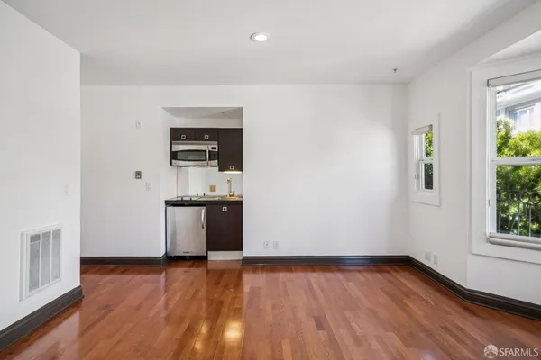 a view of a kitchen with wooden floor and electronic appliances