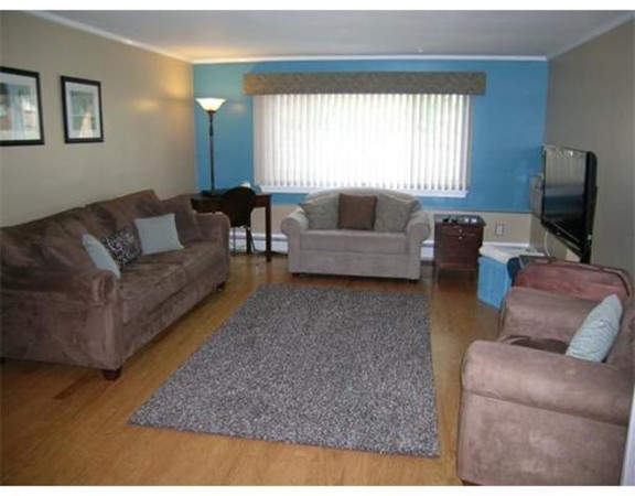 5 Hallmark Gardens, Unit 1 Burlington, MA 01803 - Photo 2 of 15 a living room with furniture and a flat screen tv