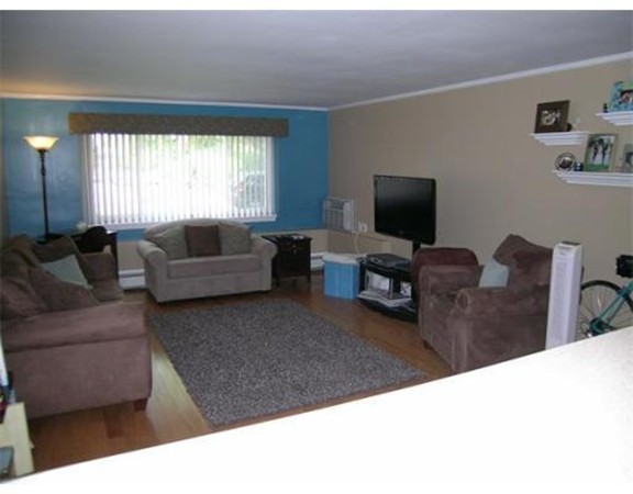 5 Hallmark Gardens, Unit 1 Burlington, MA 01803 - Photo 3 of 15 a living room with furniture window and a flat screen tv