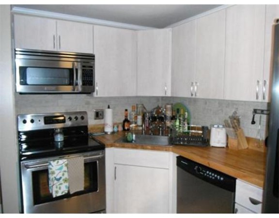 5 Hallmark Gardens, Unit 1 Burlington, MA 01803 - Photo 7 of 15 a kitchen with stainless steel appliances granite countertop a sink stove and microwave