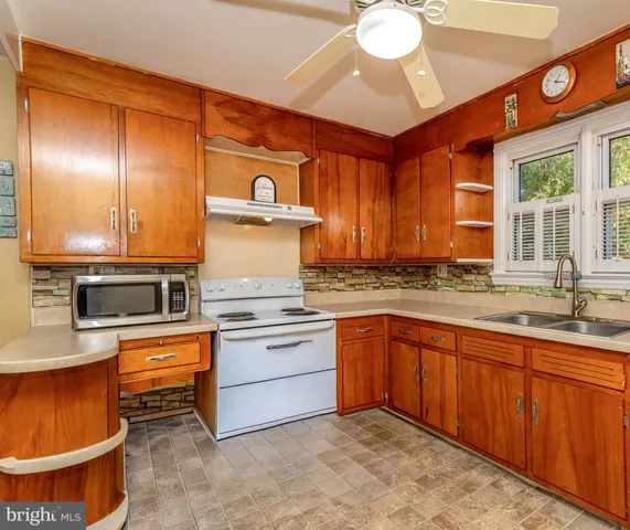 a kitchen with stainless steel appliances granite countertop a stove sink and cabinets