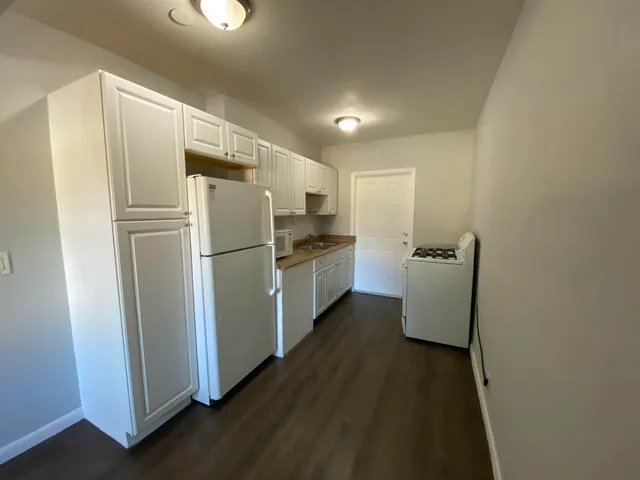 a kitchen with refrigerator and white cabinets