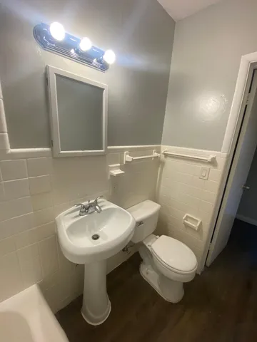 a bathroom with a sink toilet and mirror