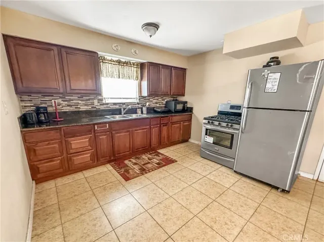 a kitchen with stainless steel appliances granite countertop a refrigerator sink and cabinets