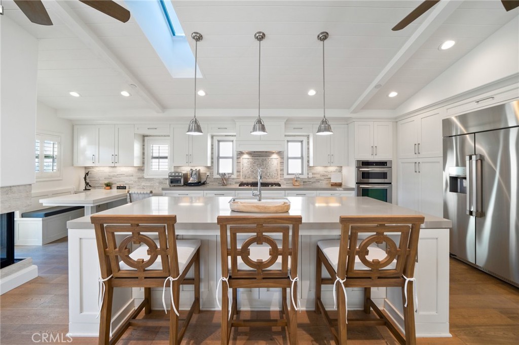 33 Cassis Dana Point, CA 92629 - Photo 13 of 49 a kitchen with refrigerator a sink and chairs