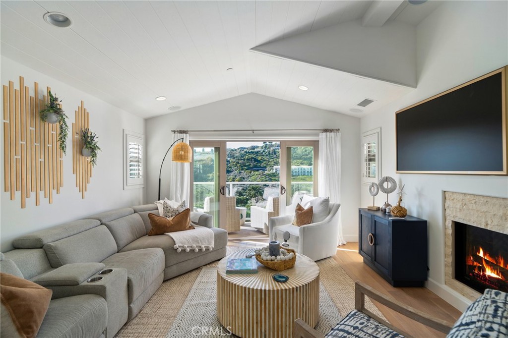 33 Cassis Dana Point, CA 92629 - Photo 14 of 49 a living room with furniture a fireplace and a flat screen tv