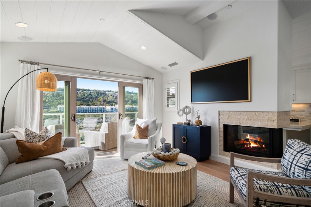 33 Cassis Dana Point, CA 92629 - Photo 15 of 49 a living room with furniture a flat screen tv and a fireplace